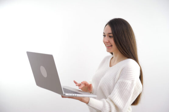 Young adult business woman typing on laptop computer working in internet, beautiful female professional user lady using pc technology doing online job in office or browsing web sit at home table