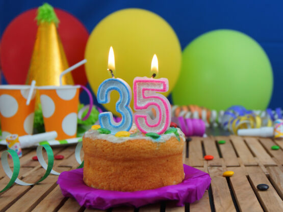 vecteezy_birthday-cake-35-with-candles-on-rustic-wooden-table-with_53243211_vv