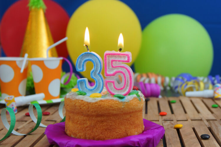 vecteezy_birthday-cake-35-with-candles-on-rustic-wooden-table-with_53243211_vv